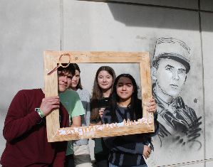 Les vainqueurs de l'escape game, avec en arrière plan le visage du commandant Marey. un des héros de la Résistance. 